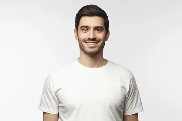 A close-up of a man smiling, showcasing clean and white teeth, representing good oral hygiene and dental care.