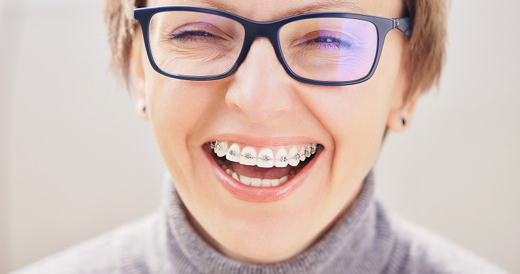 A woman in glasses and braces smiling
